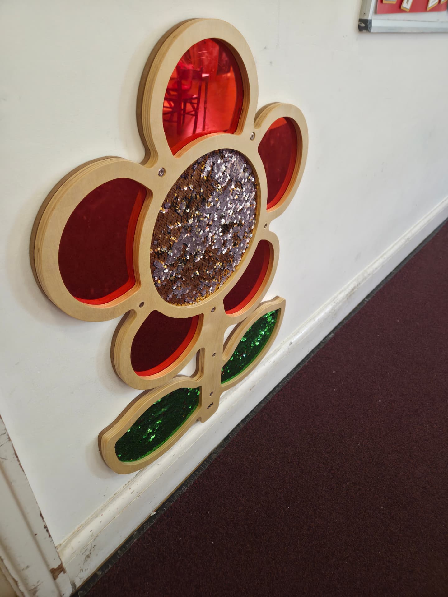 Wooden sensory flower wall panel with sequin and tactile petals in the Red Room