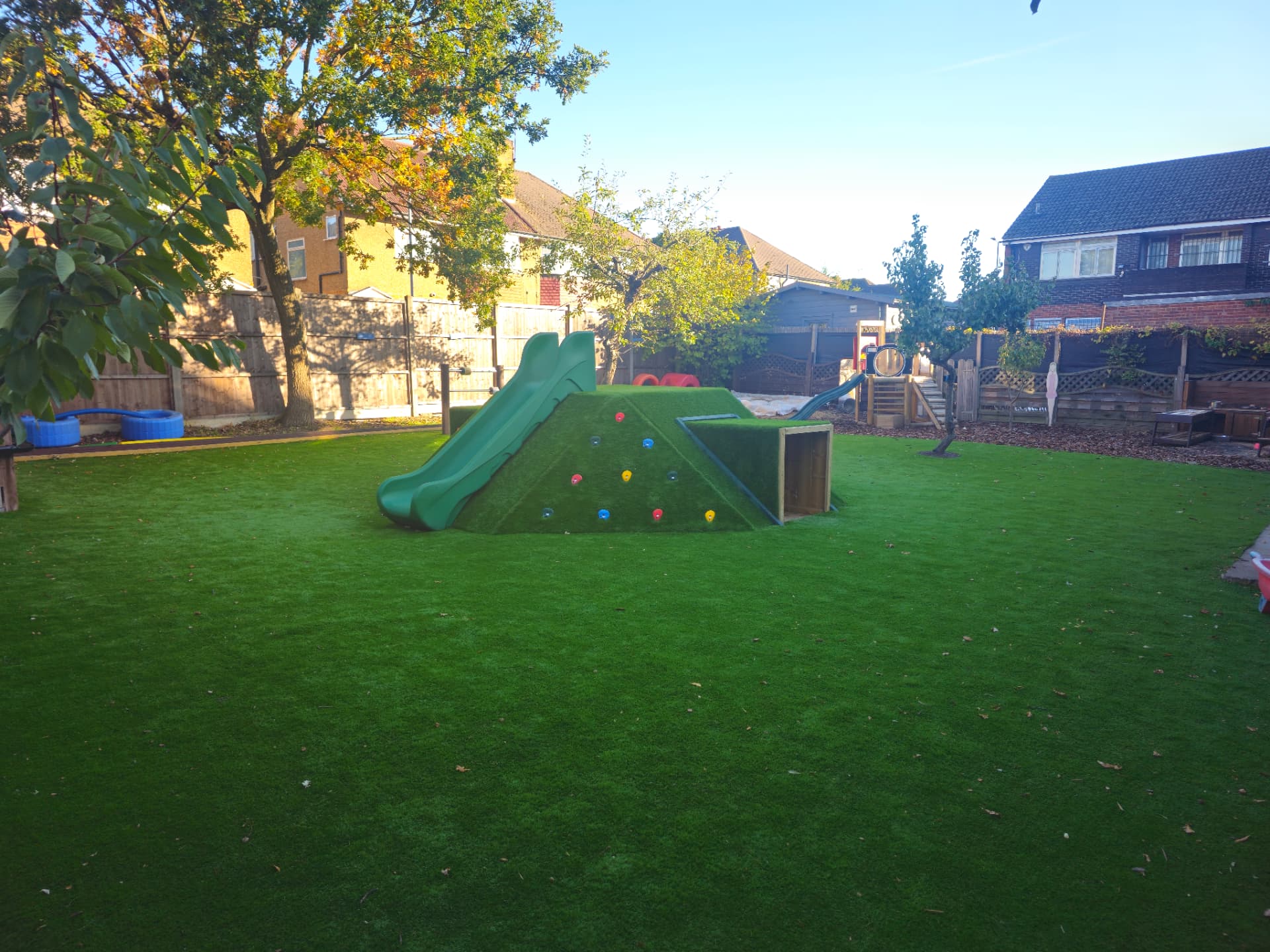Our large garden with the grass-covered climbing mound, slide and tunnel