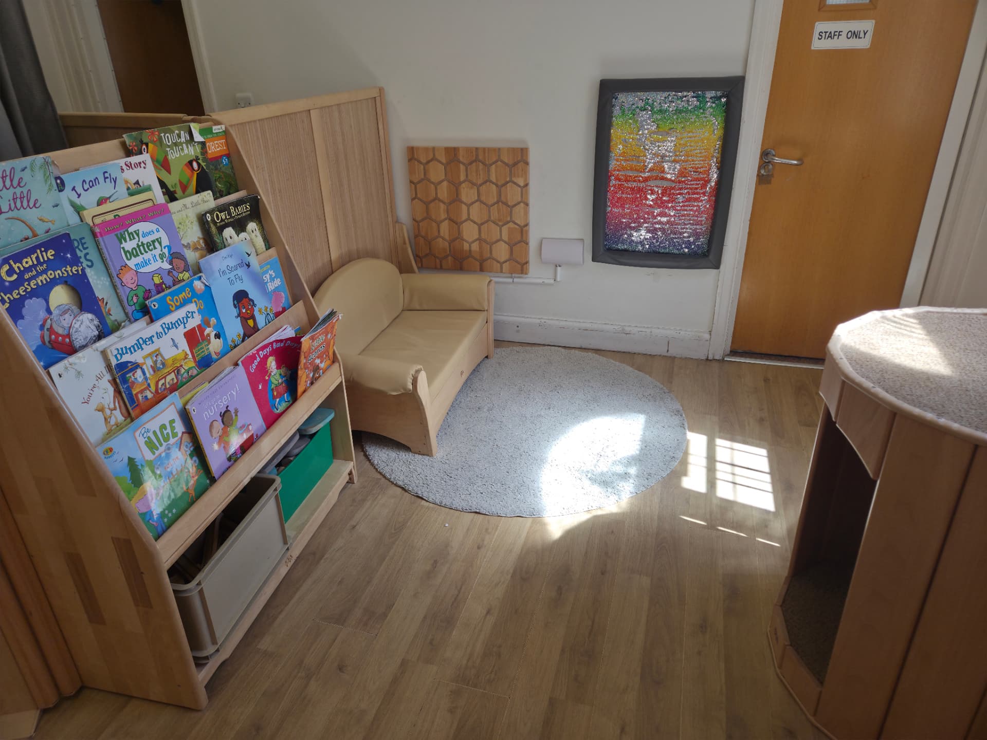 Cosy book corner with cosy nook to help with self-regulation, plus a calming honeycomb board that changes colour when children touch it